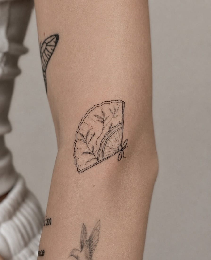 Fine line folding fan with foliage tattoo by an Essex Fine Line Tattoo Academy student